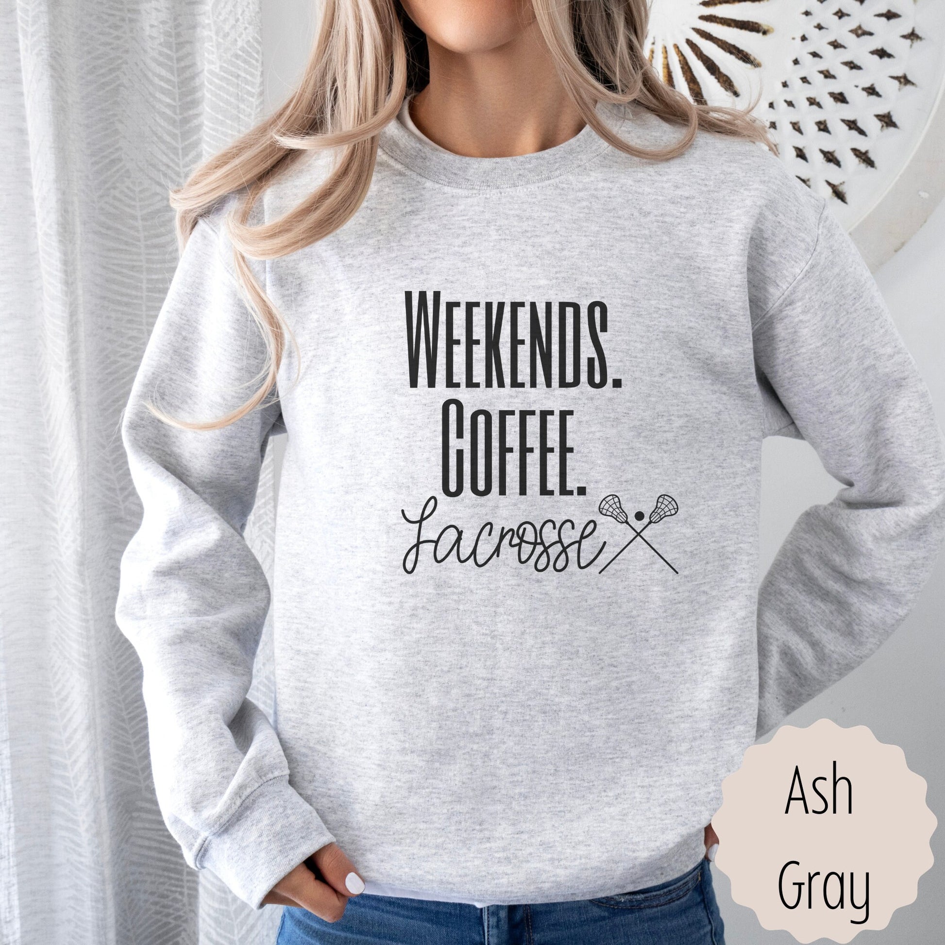 lacrosse fan pullover for Moms that says weekends coffee lacrosse with a black outlined lacrosse sticks on the bottom. This sweatshirt comes in sand, white, black, gray, and heareth dark gray.