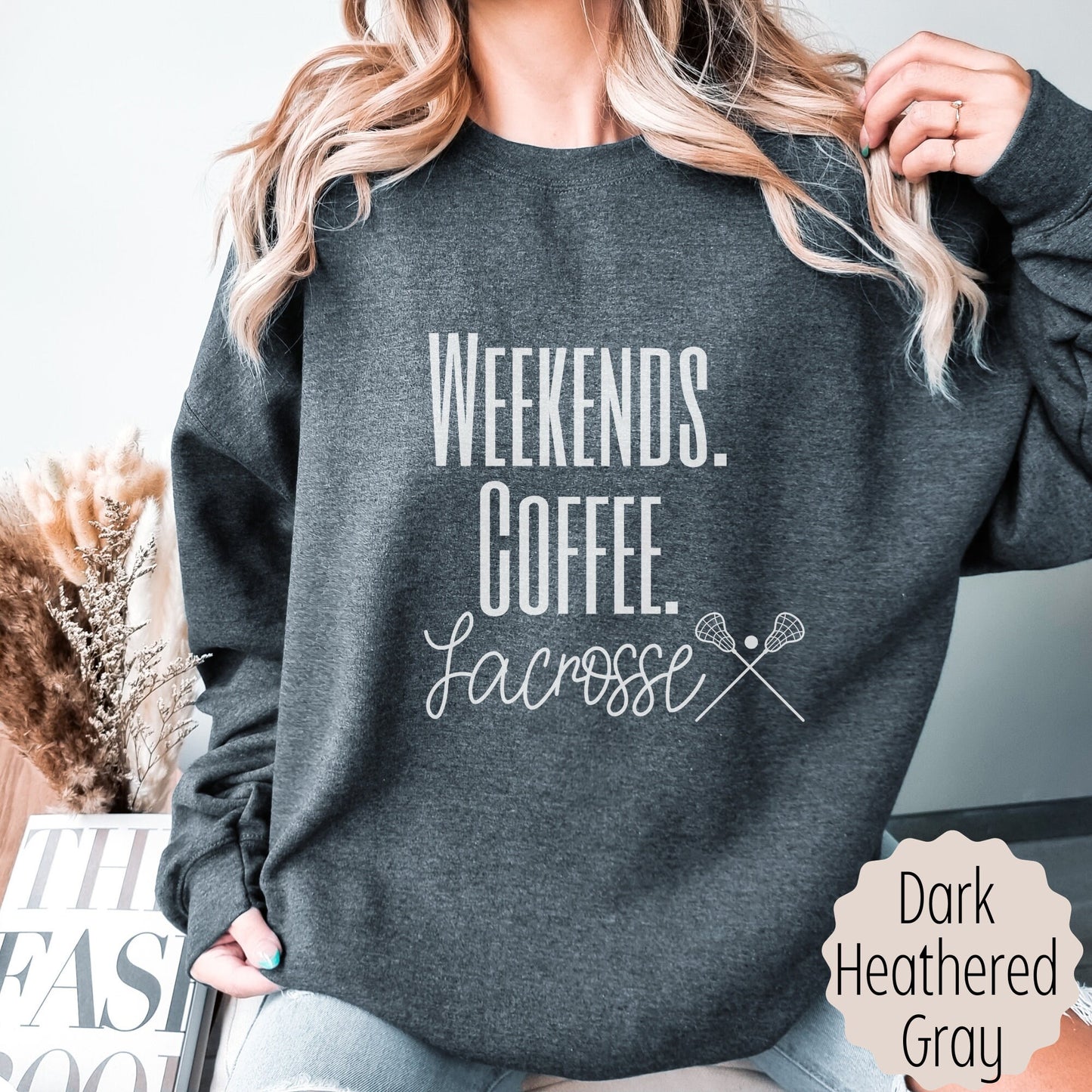 lacrosse coach gift for Moms that says weekends coffee lacrosse with a black outlined lacrosse sticks on the bottom. This sweatshirt comes in sand, white, black, gray, and heareth dark gray.