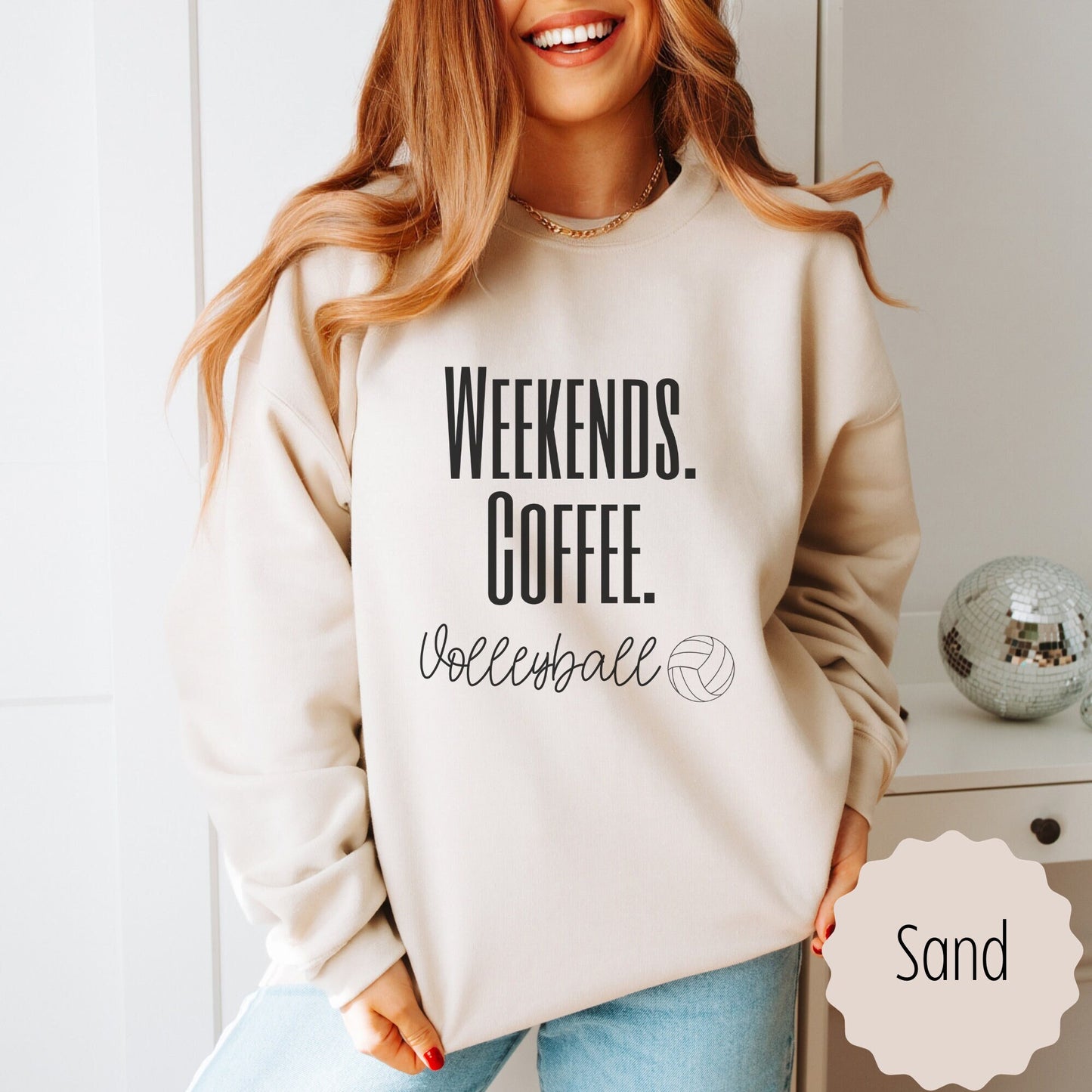 volleyball sweatshirt that says weekends coffee volleyball with a black outlined volleyball on the bottom. This sweatshirt comes in sand, white, black, gray, and heareth dark gray.