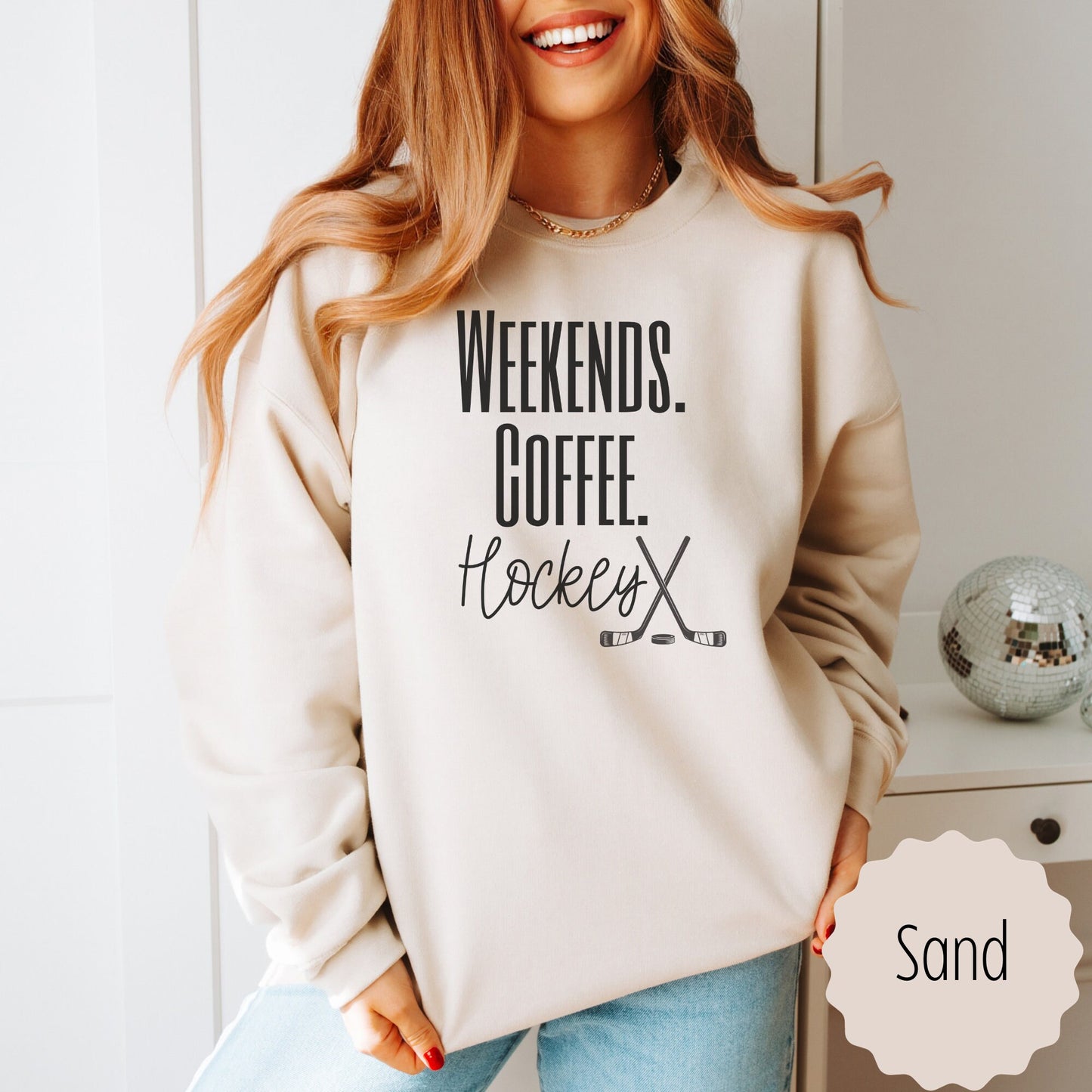 game day sweatshirt that says weekends coffee hockey with a black outlined hockey sticks on the bottom. This sweatshirt comes in sand, white, black, gray, and heareth dark gray.