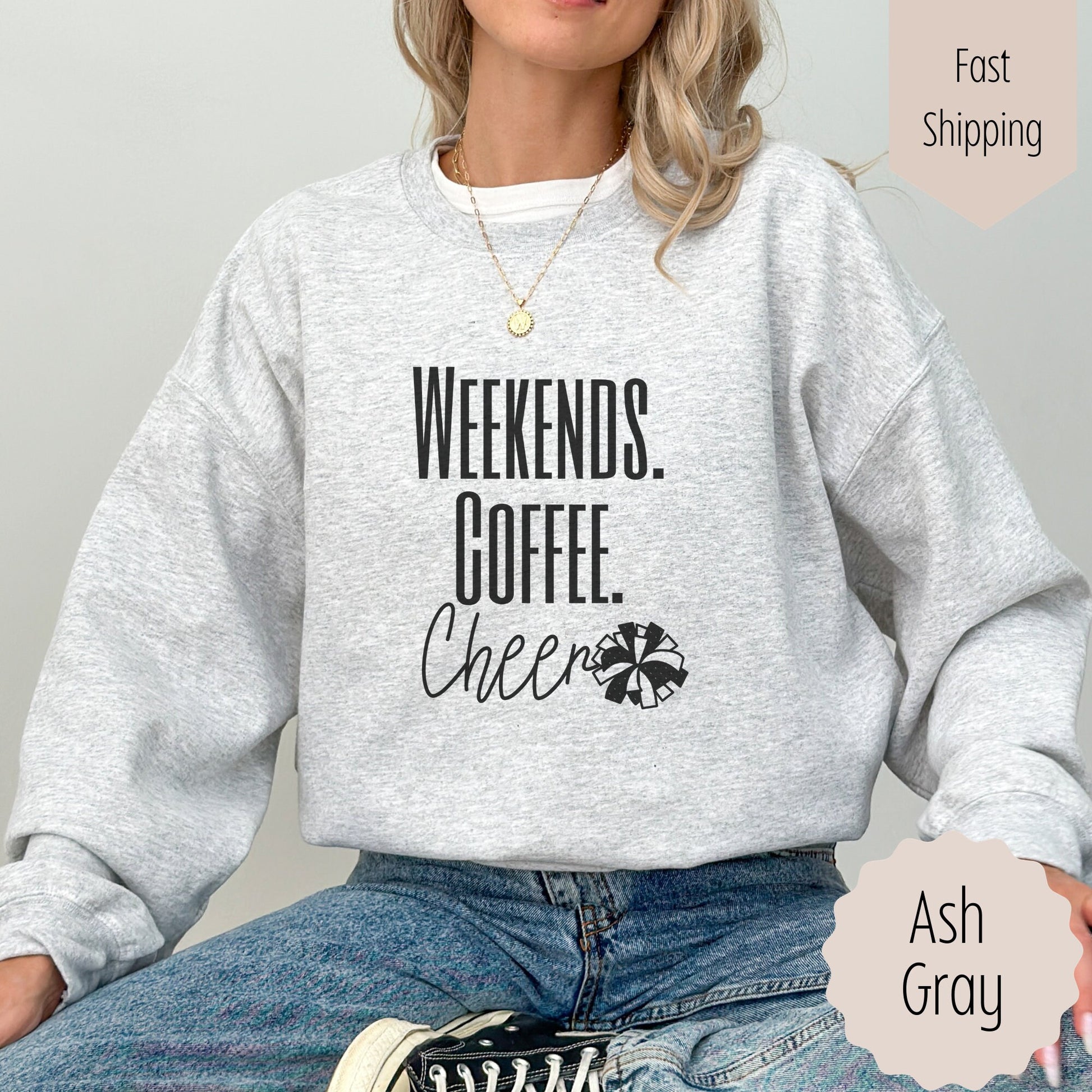 cheer mom competition sweatshirt that says weekends coffee cheer with a pom pom. This is plain text lettering and the sweatshirt comes in the colors ash grey, black, sand, white, and dark heathered grey.