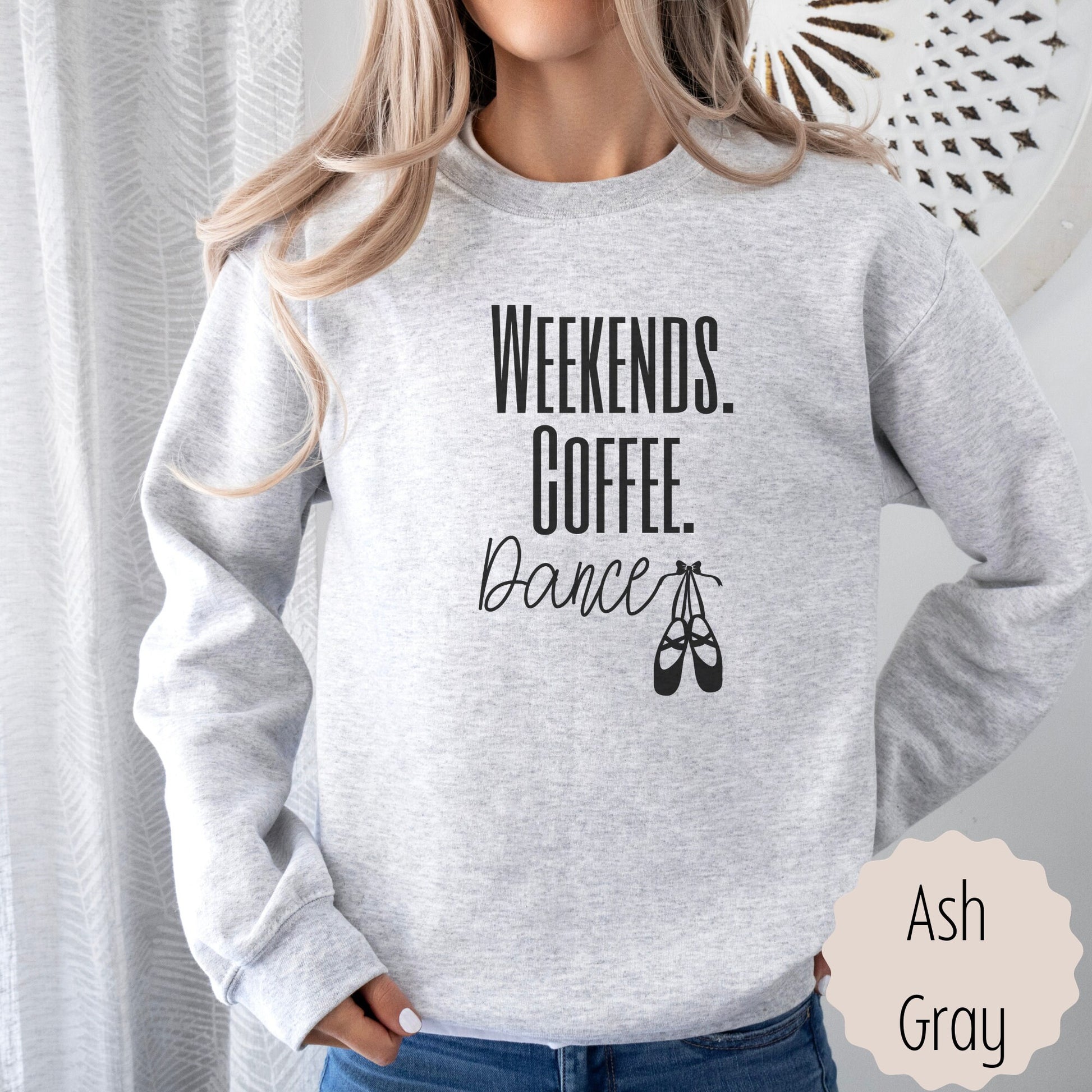 dance lover sweatshirt that says weekends coffee dance with ballet slippers after the word dance. This sweatshirt comes in sand, black, white, dark heathered gray, and ash gray.