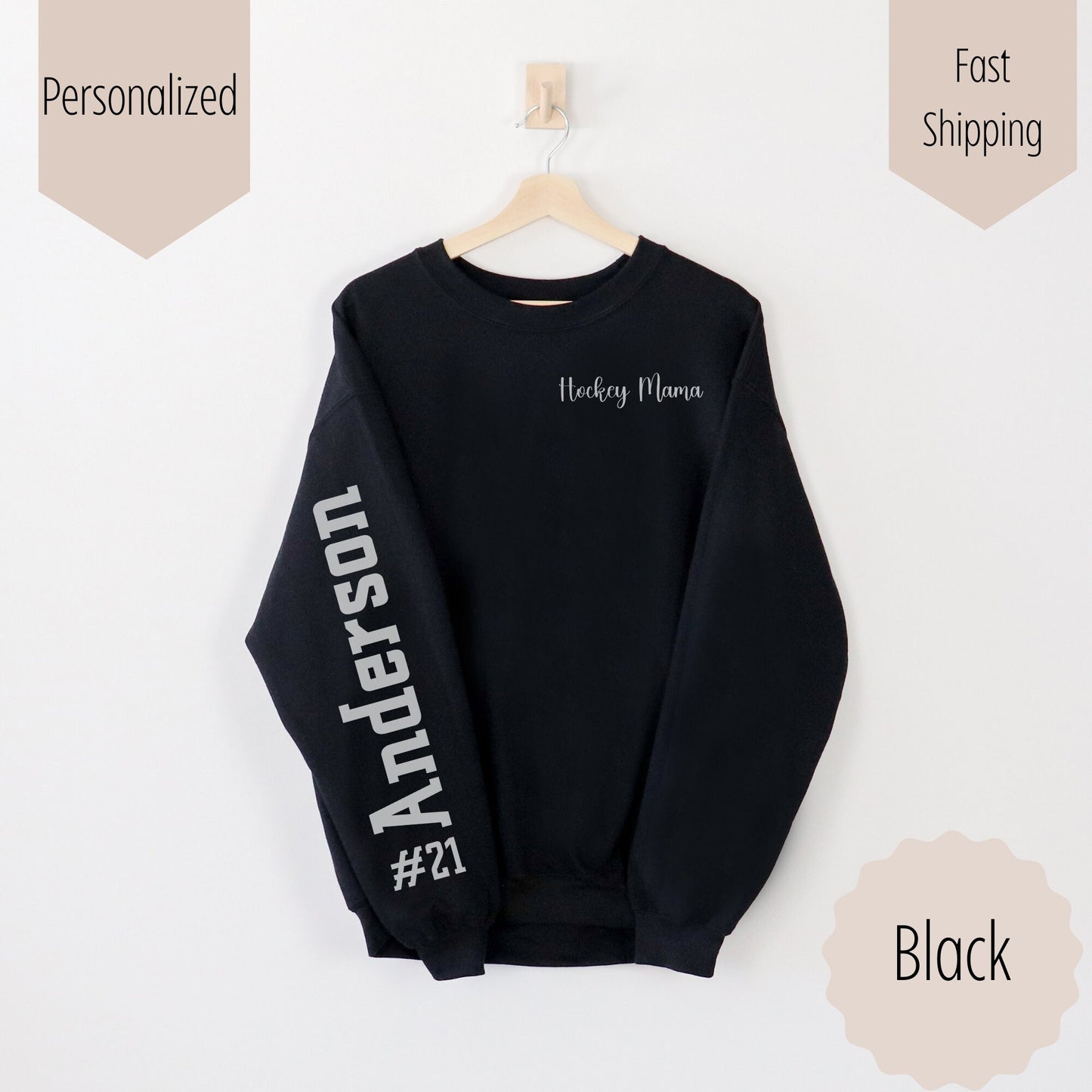 hockey mama sweatshirt with name and number on sleeve. This shirt says hockey mama on the pocket area of the sweatshirt and the number with last name on the sleeve. This comes in sand, white, black, and ash gray.